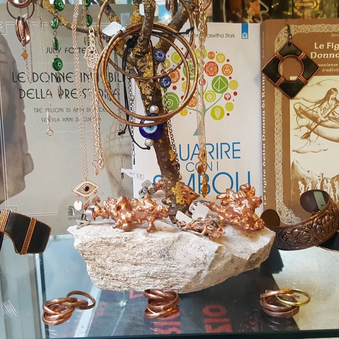 Ciondoli con l’occhio e bracciali di rame accanto al libro Guarire con i simboli